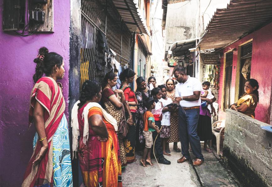 Un miembro del personal de World Mosquito Program con miembros de la comunidad en Sri Lanka