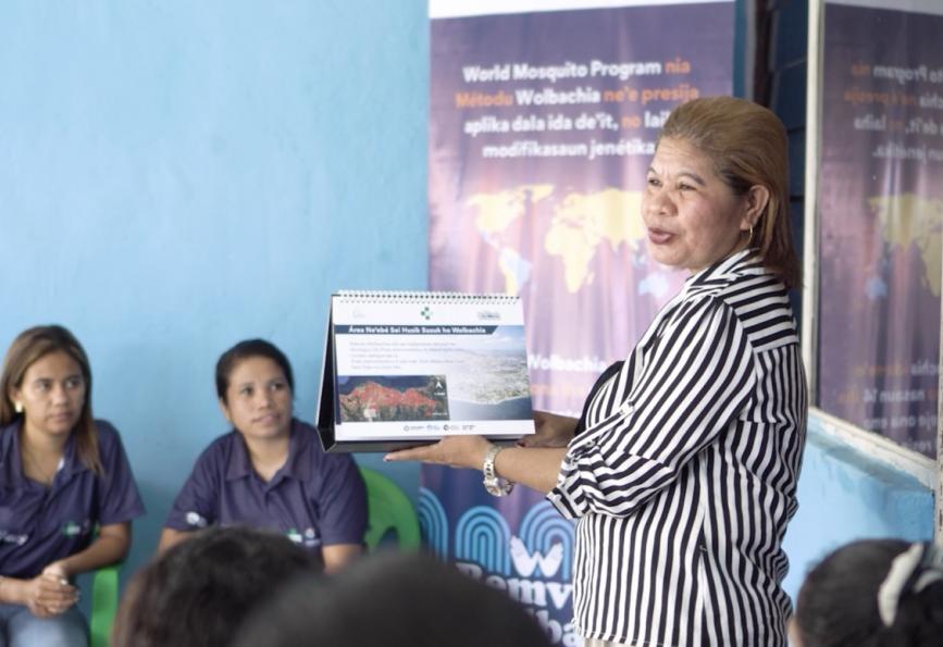 Fotografía de Afliana Soares hablando con un grupo de miembros de la comunidad en Timor Oriental 